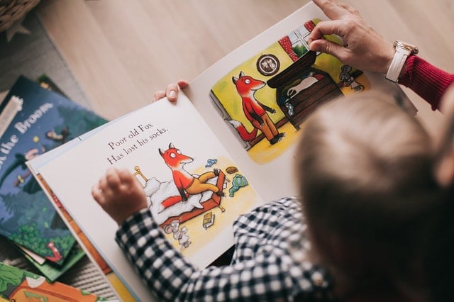 Kind met ouder leest boek